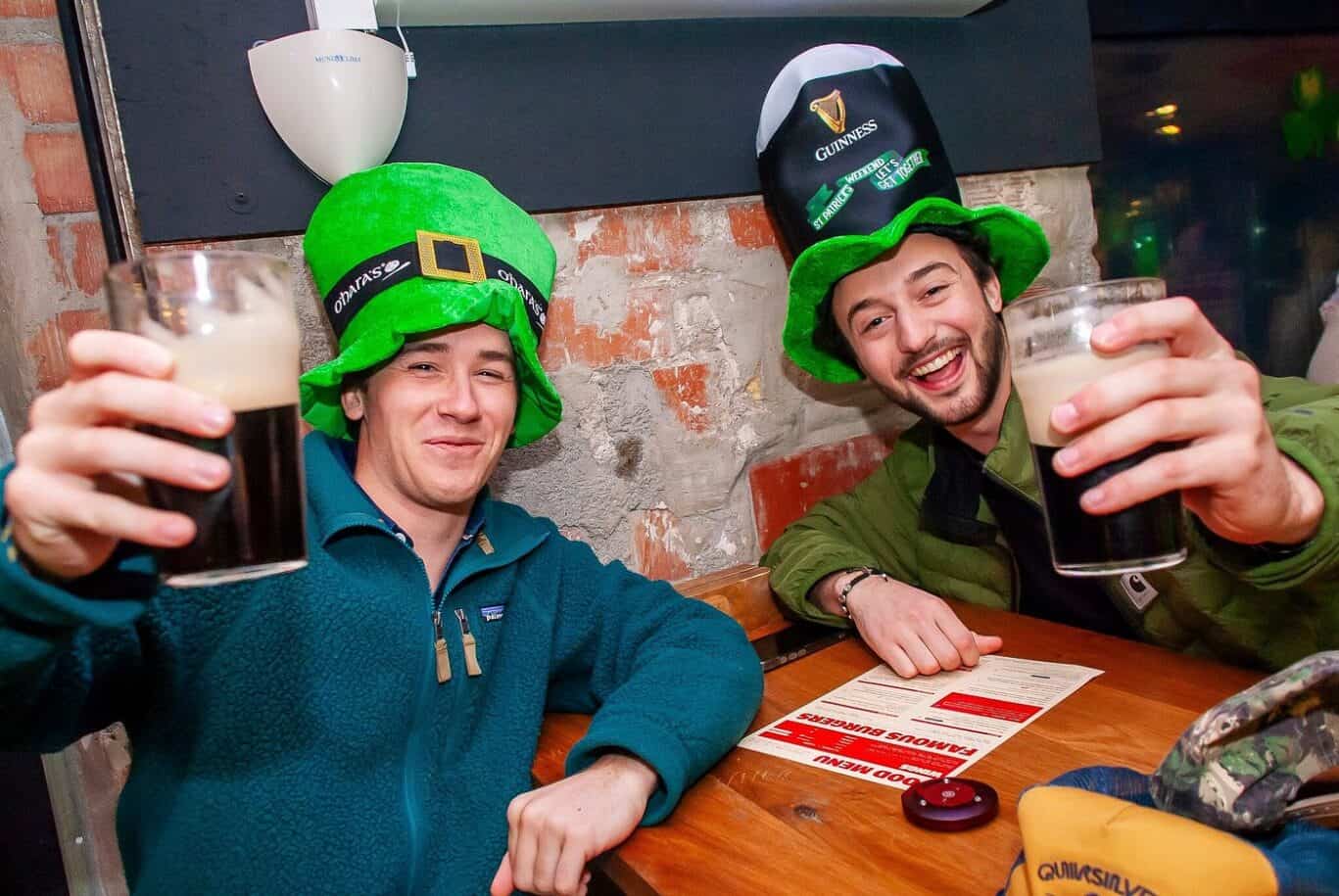 Two friends celebrating St. Patrick's Day at St Christopher’s Barcelona, wearing fun leprechaun hats.