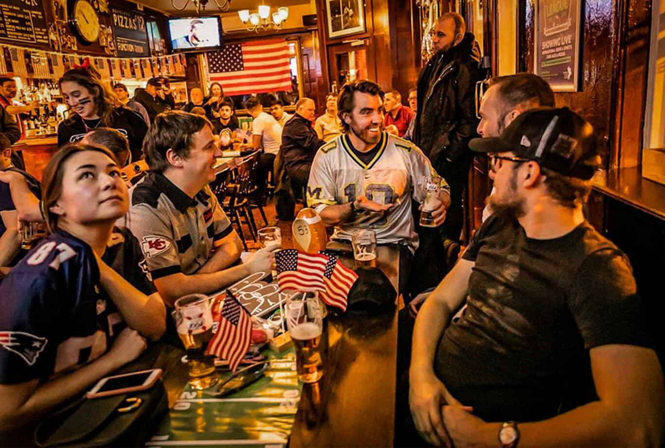 Group of friends watching sports at Liverpool Street Hostel bar.