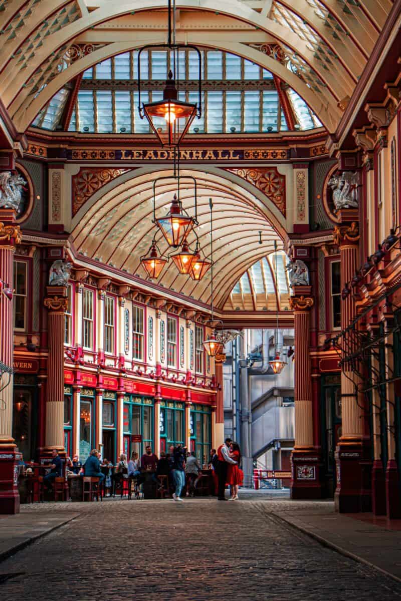 Interior view of Liverpool Street Hostel arcade with shops and travellers in London.