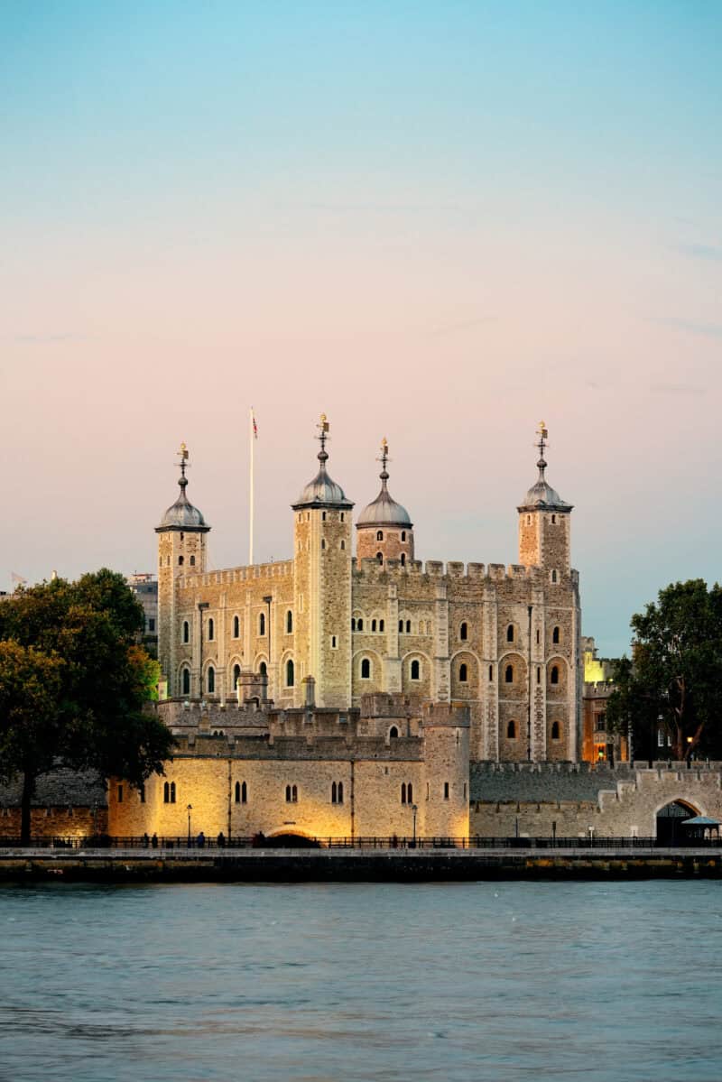 View of a historic castle near Liverpool Street Hostel, London, with water in the foreground.