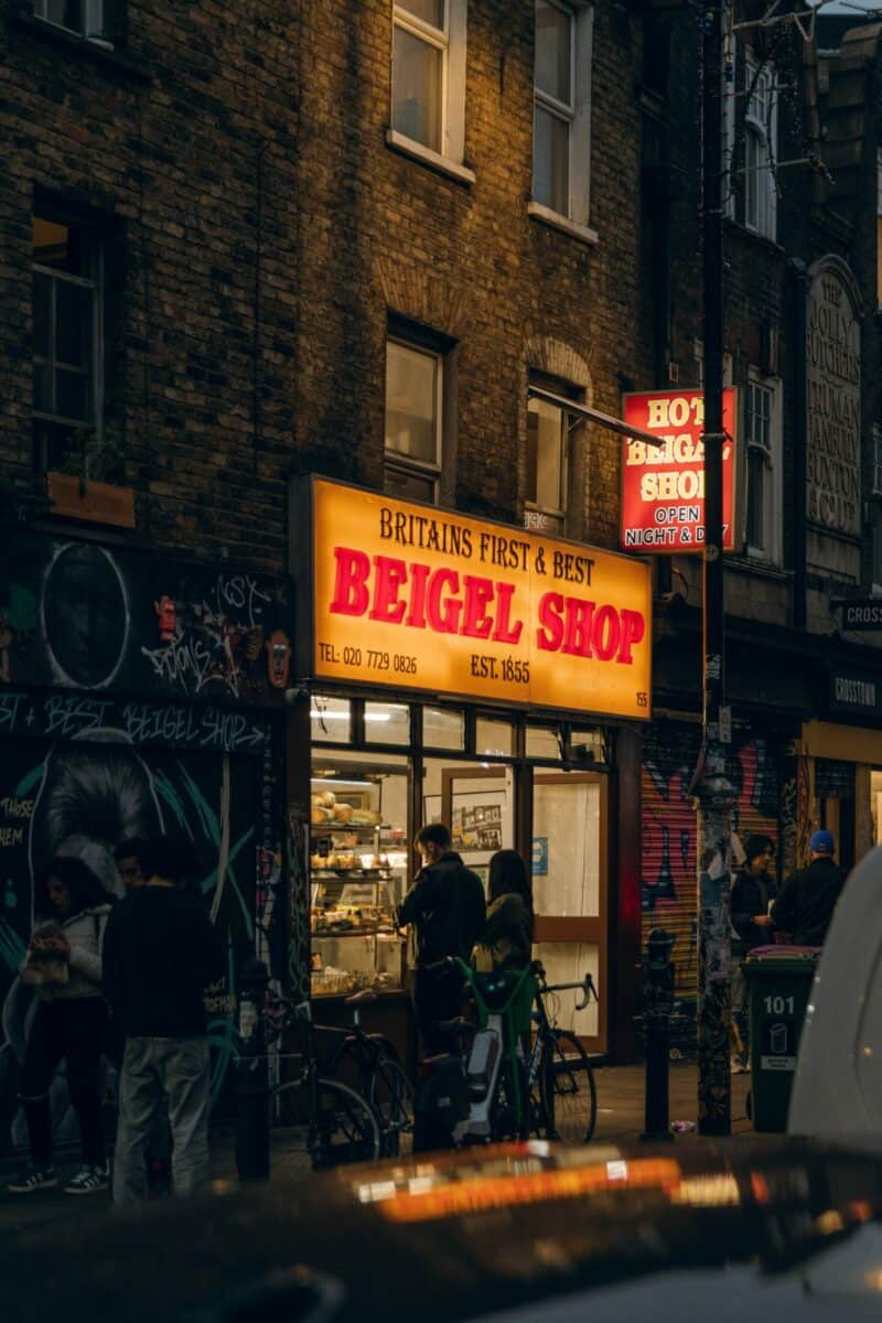 View of a Beigel Shop near St Christopher's Liverpool Street hostel in London, with people outside.
