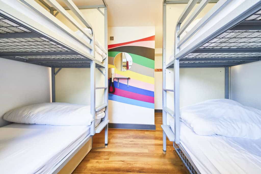 Shared dorm room at St Christopher's London Bridge with bunk beds and colourful wall art.