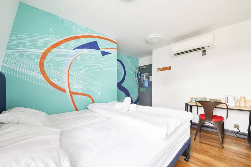Modern hostel room at London Bridge with colourful wall art and comfortable beds.