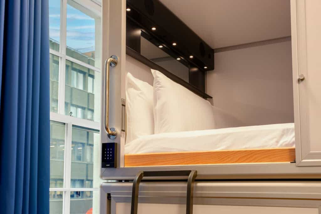 Modern hostel room at London Bridge with bunk bed and large window.