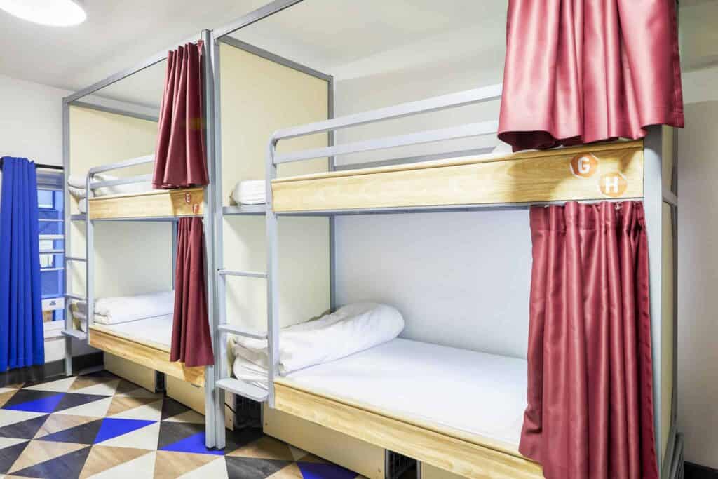 Bunk beds with privacy curtains at St Christopher’s London Bridge Hostel.