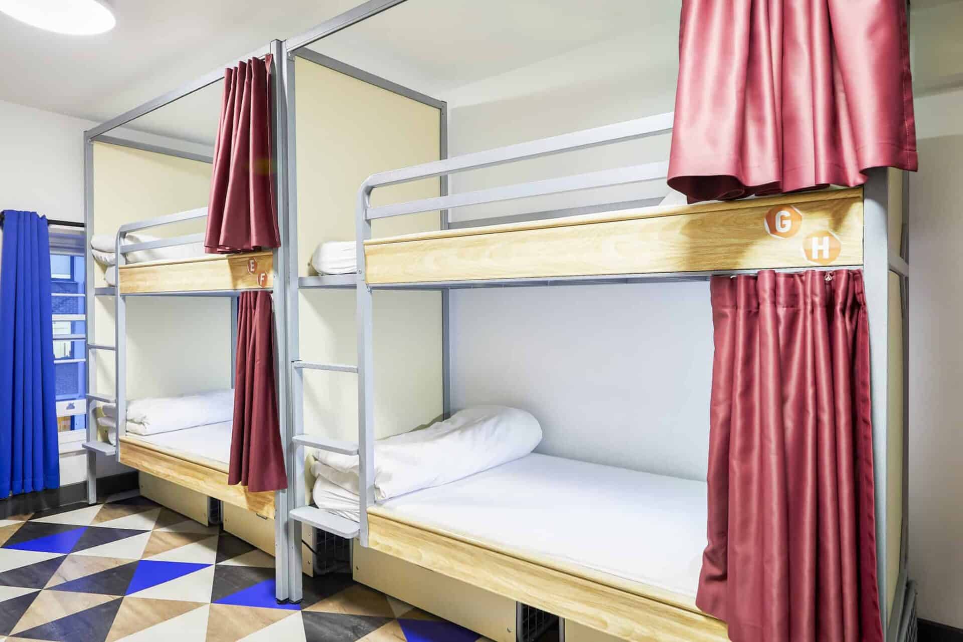Bunk beds with privacy curtains at St Christopher’s London Bridge Hostel.