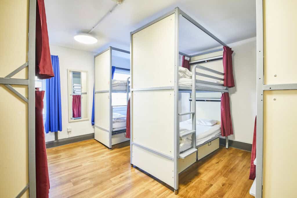 Dorm room at St Christopher's London Bridge hostel with bunk beds and colourful curtains.