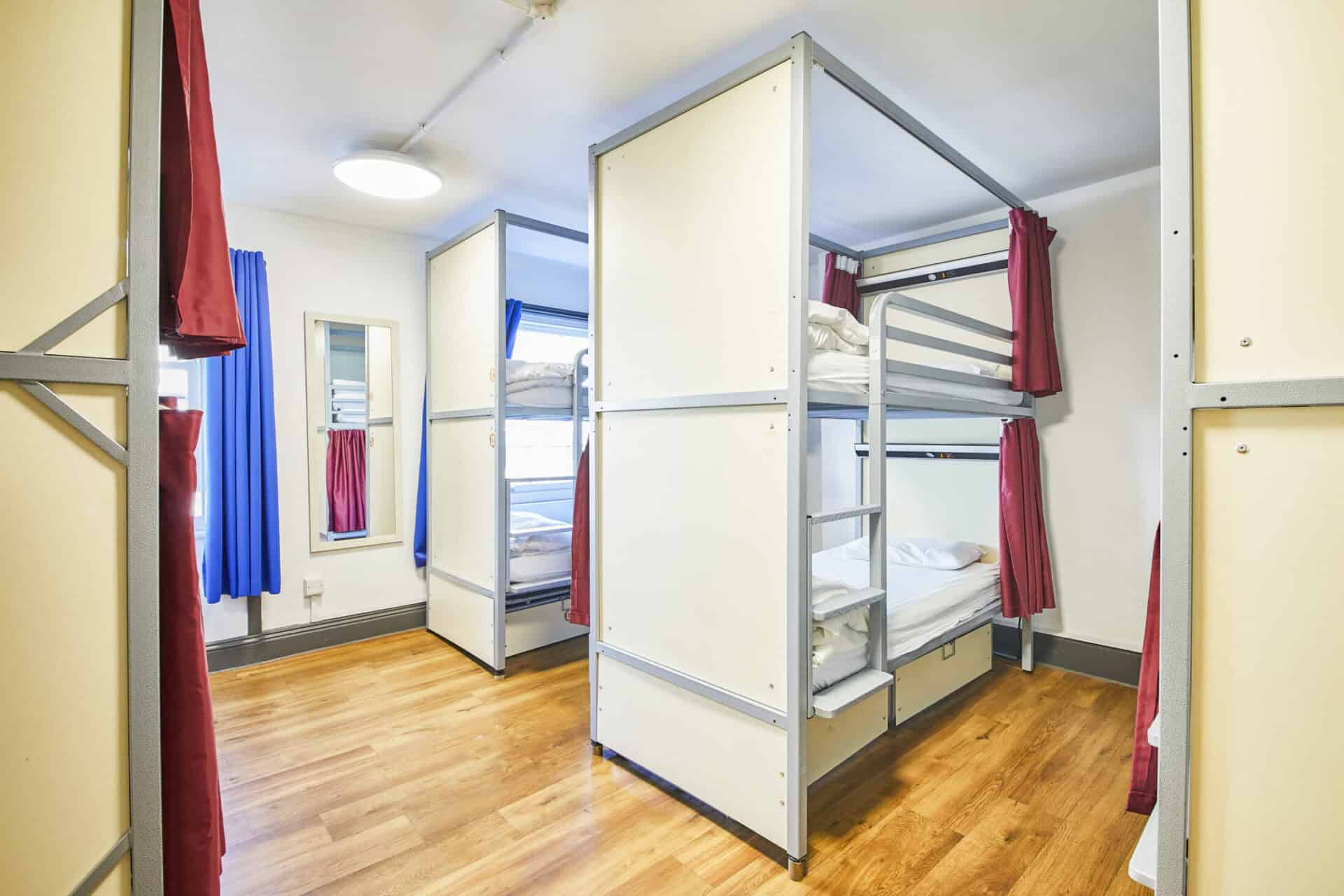 Dorm room at St Christopher's London Bridge hostel with bunk beds and colourful curtains.