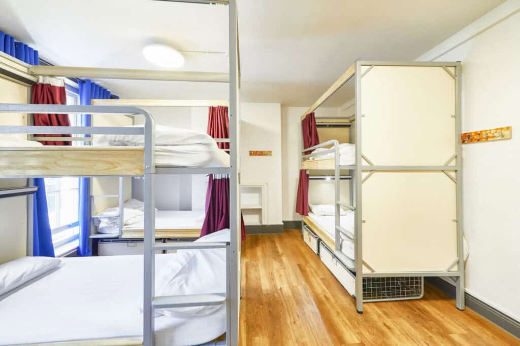 Mixed dorms at St Christopher's London Bridge hostel, showing bunk beds and bright curtains.