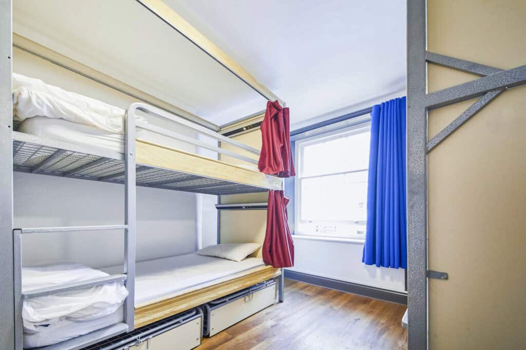 Dorm room at St Christopher's London Bridge with bunk beds and colourful curtains.
