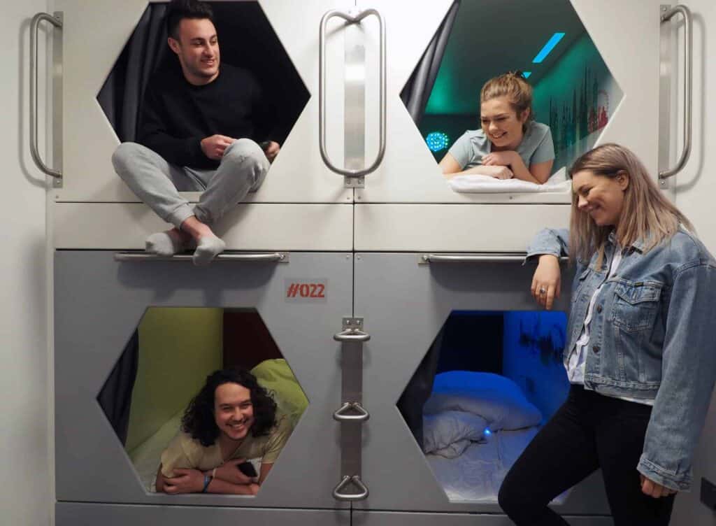 Young people relaxing and socialising in a contemporary hostel room.