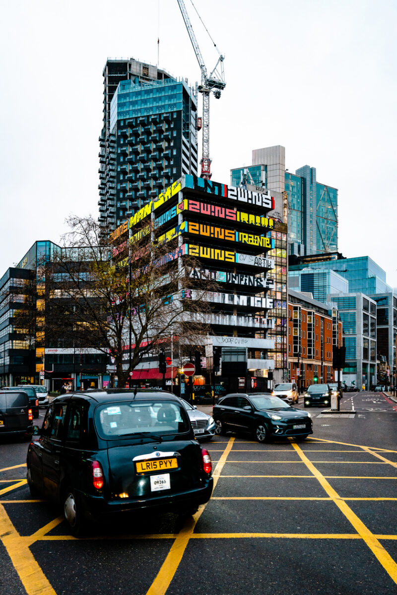Black cab and traffic on busy intersection in London, UK