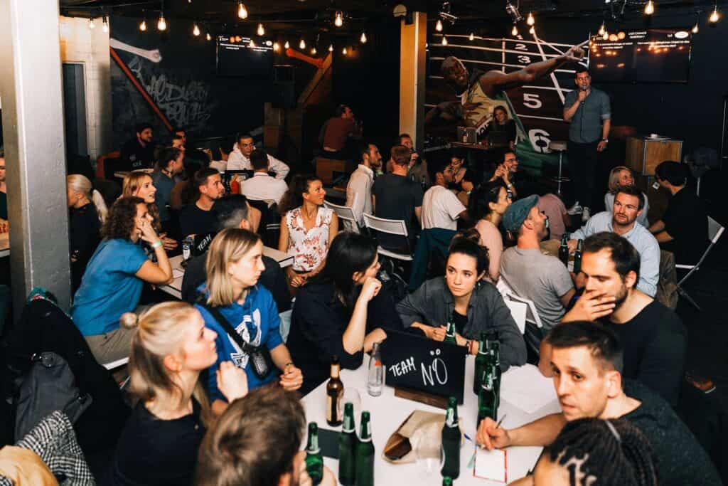 Social scene at St Christopher's Berlin Mitte with travellers enjoying drinks and live music.