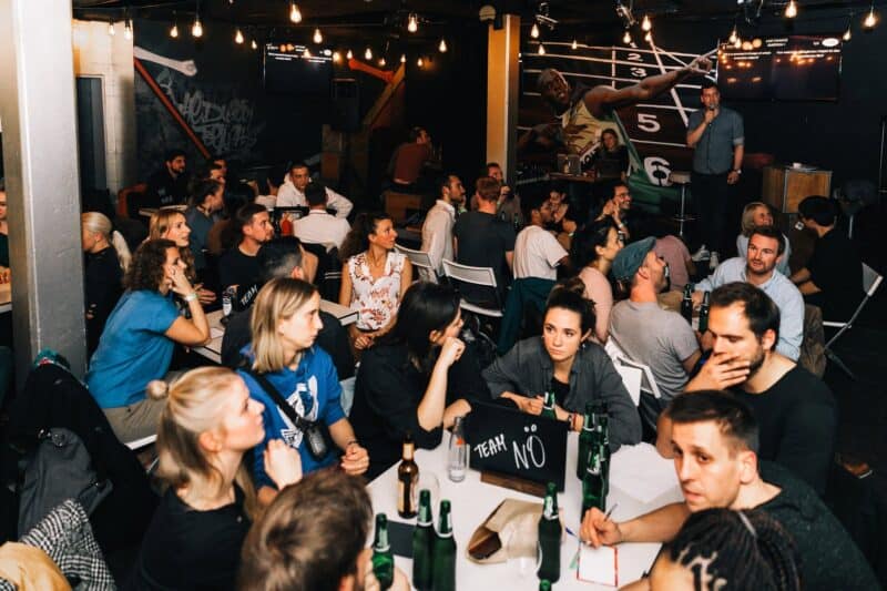 Social scene at St Christopher's Berlin Mitte with travellers enjoying drinks and live music.