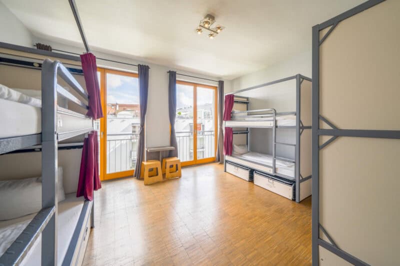 Bright dorm room with bunk beds and large windows in Mitte, Berlin.