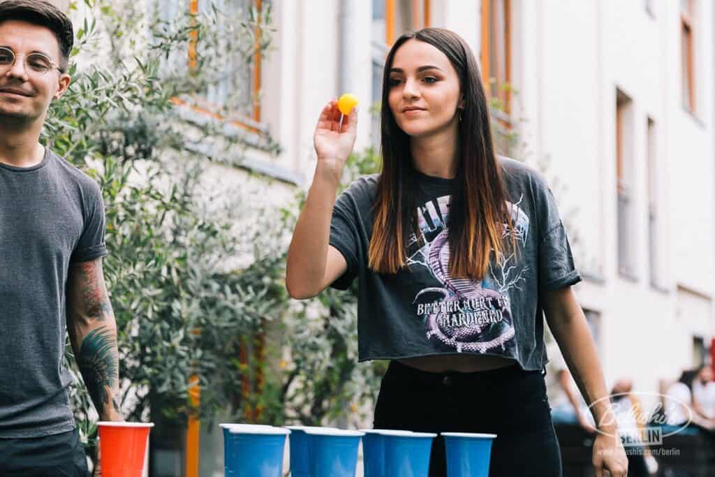 Young woman playing beer pong at St Christopher’s Berlin Mitte hostel.