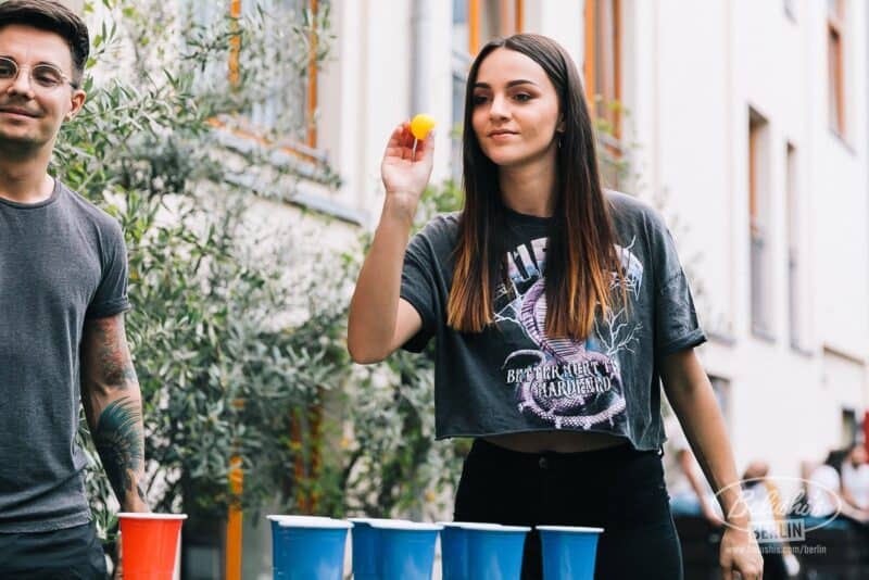 Young woman playing beer pong at St Christopher’s Berlin Mitte hostel.