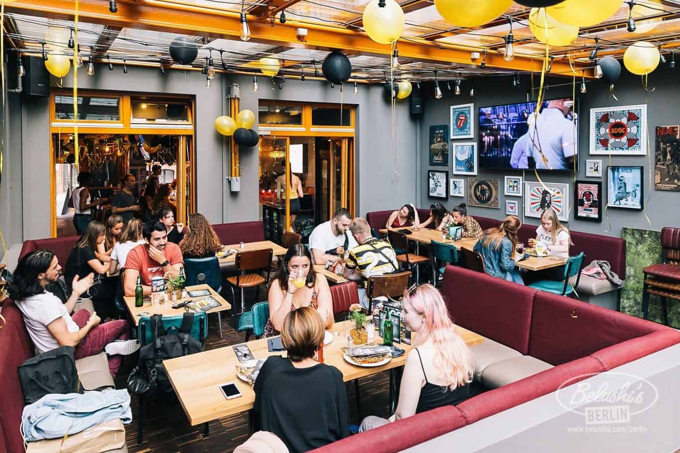 Hostel lounge in Berlin with vibrant social space, colourful decor, and communal seating for travell.