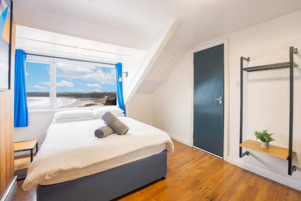 Comfortable hostel room at St Christopher’s Newquay, with sea views and modern amenities.