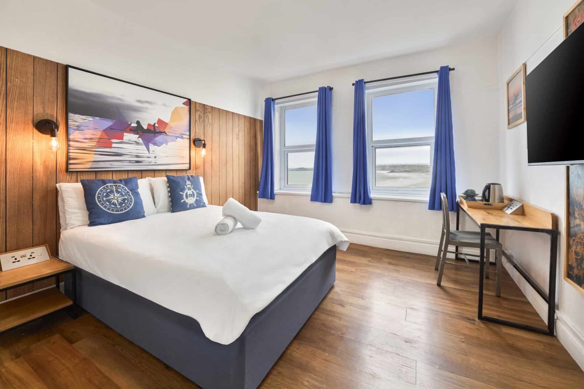 Double room with sea views at St Christopher’s Newquay hostel, featuring modern decor, free Wi-Fi, a.