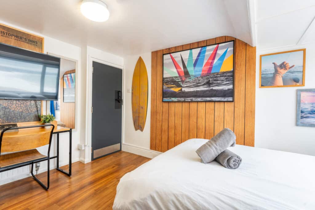 Comfortable hostel room at St Christopher’s Newquay with beach-themed decor and modern amenities.
