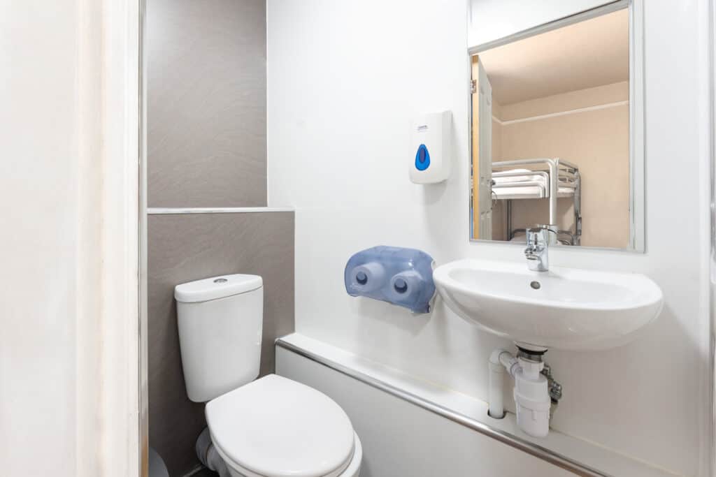 Modern ensuite bathroom with toilet and sink at St Christopher’s Newquay hostel.