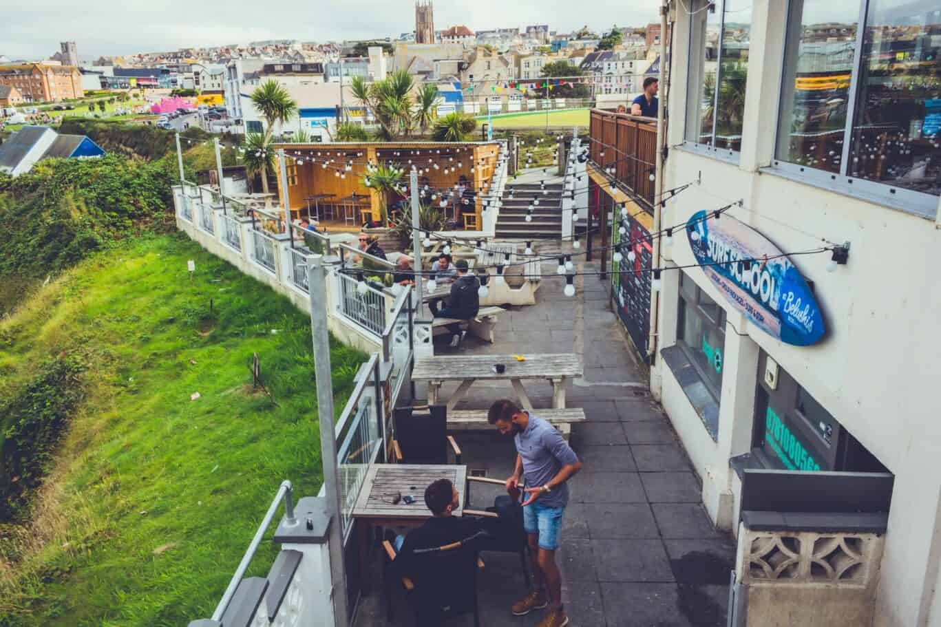 Rooftop terrace at St Christopher’s Newquay hostel with outdoor seating and city views.