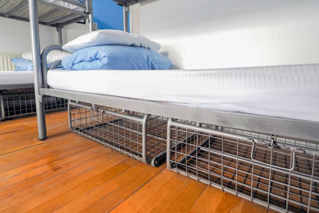 Bunk bed with metal frame and storage drawers in a hostel room at St Christopher’s Newquay.