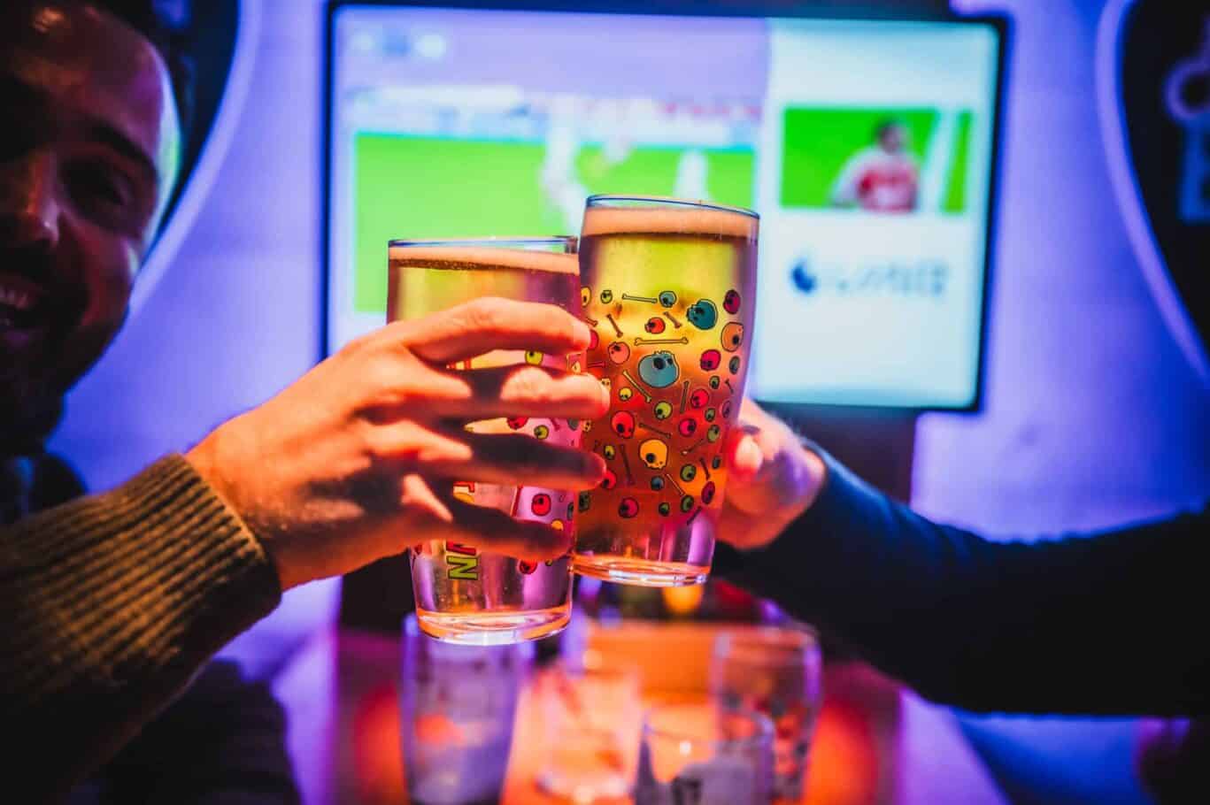 Group of friends enjoying colourful drinks at St Christopher’s Newquay hostel bar.