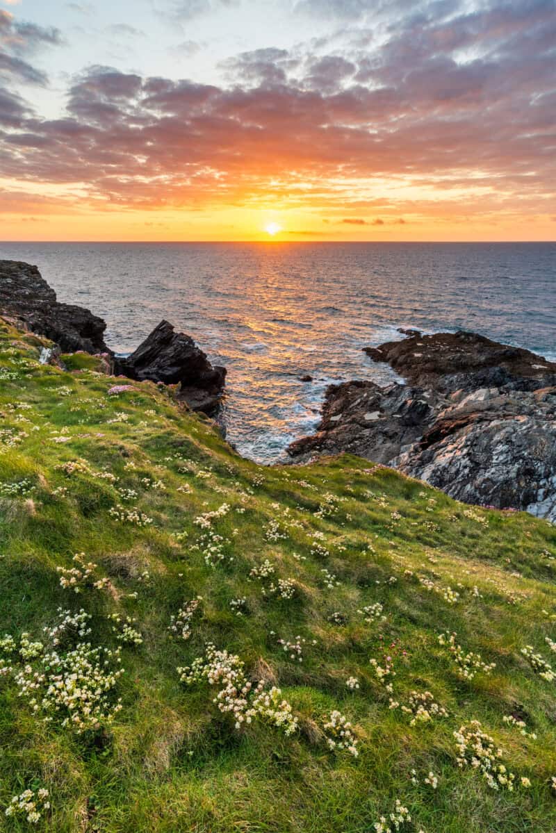 Beautiful vibrant Summer sunset landscape image of Pentire Headland in Cornwall England with dramatic sky