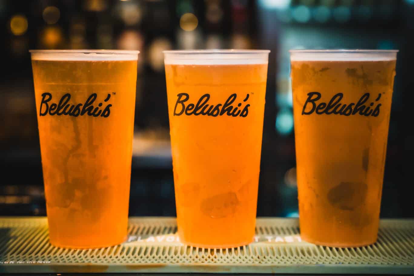 Three pints of beer with Belushi’s logo on a bar counter in Edinburgh.