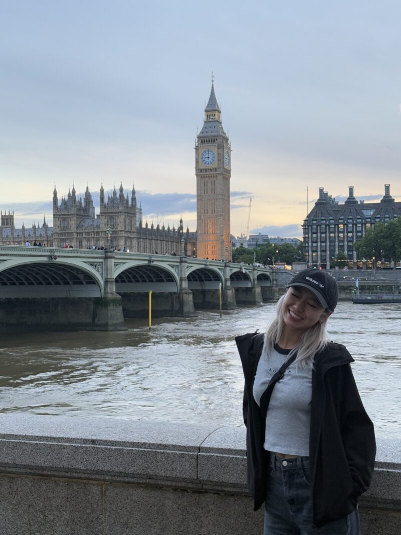 Traveller in front of Big Ben and the Houses of Parliament by the river.