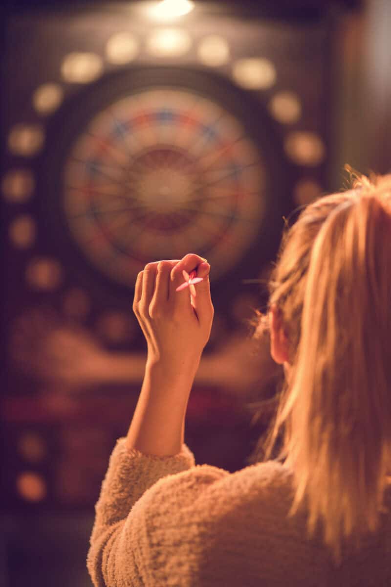 Woman playing darts at St Christopher’s Paris - Canal hostel bar.