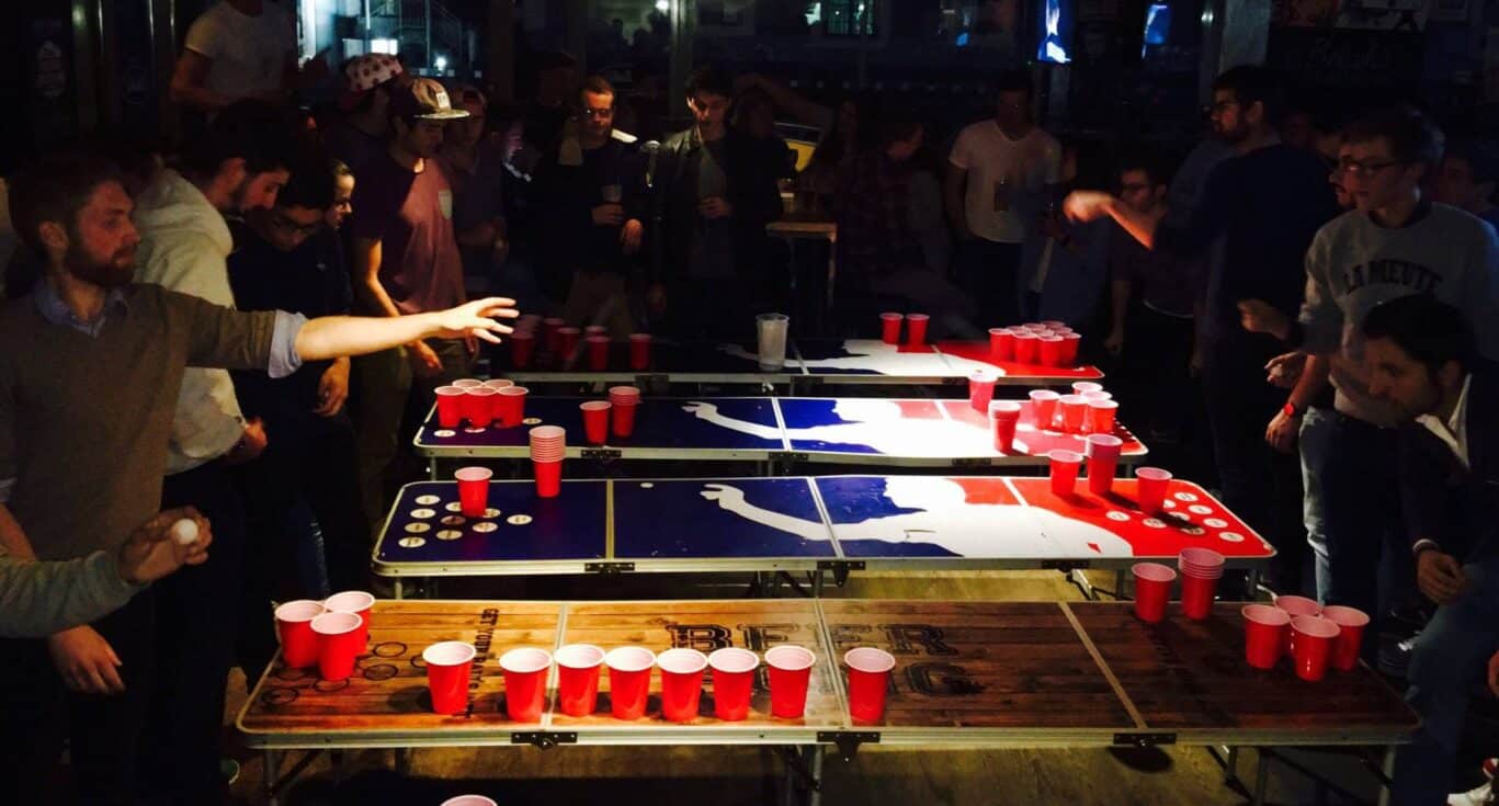 People playing beer pong at Canal Hostel Paris, social and lively atmosphere.