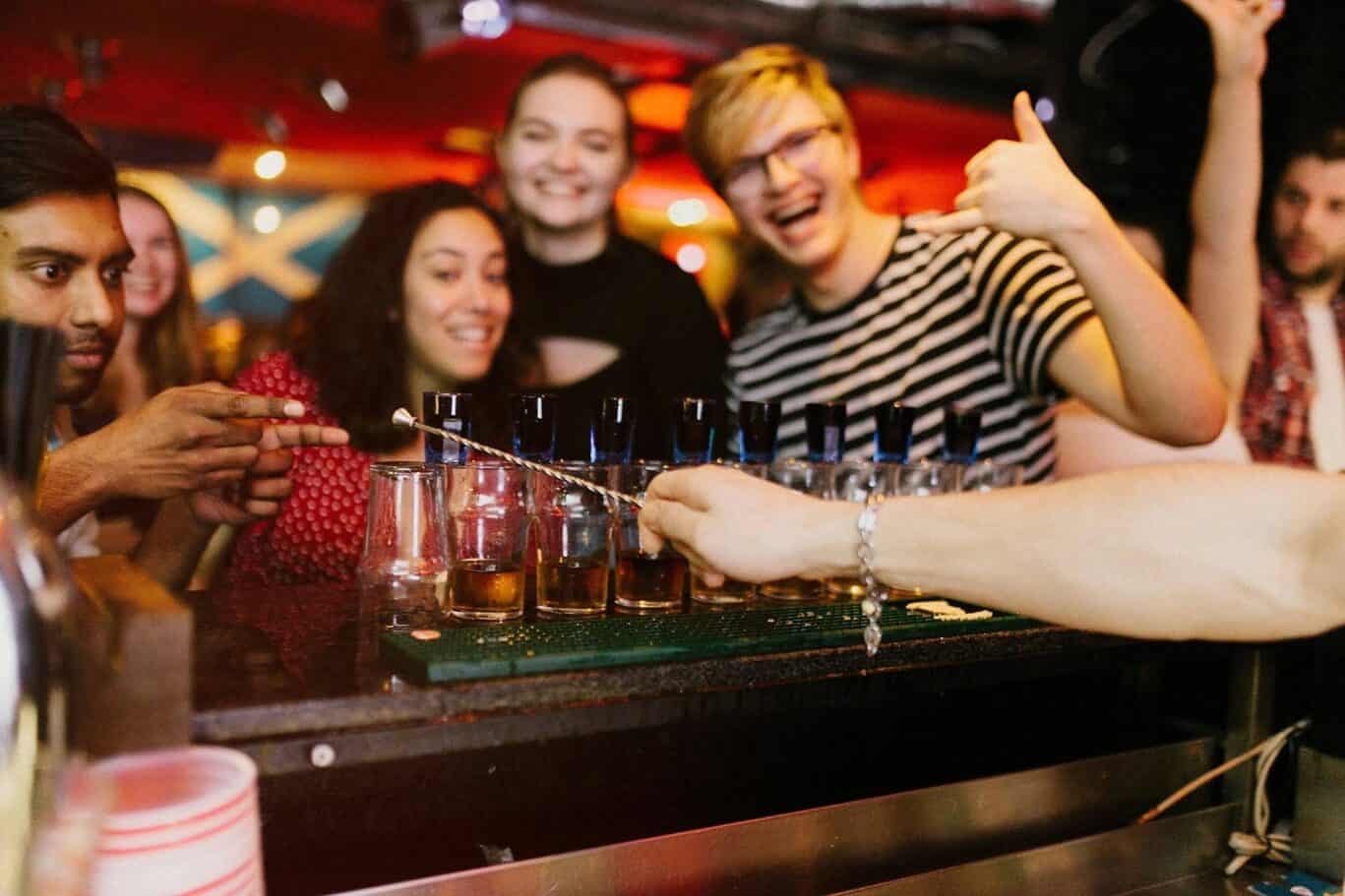 Group of friends having drinks at the bar in St Christopher’s Paris - Canal hostel.