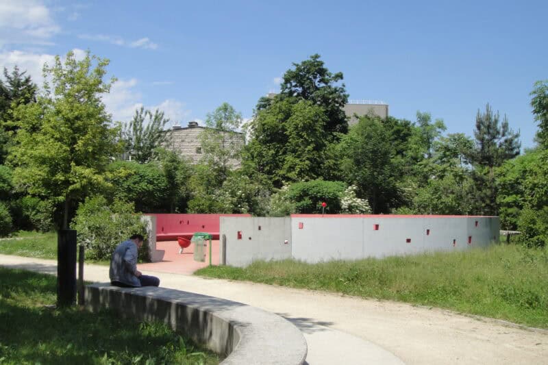 View of a park near St Christopher's Paris - Canal with a person sitting on a bench.