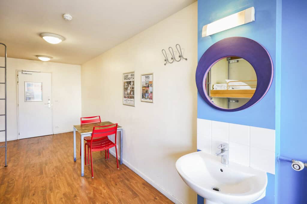 Bright hostel common area with colourful furniture and wall decorations.