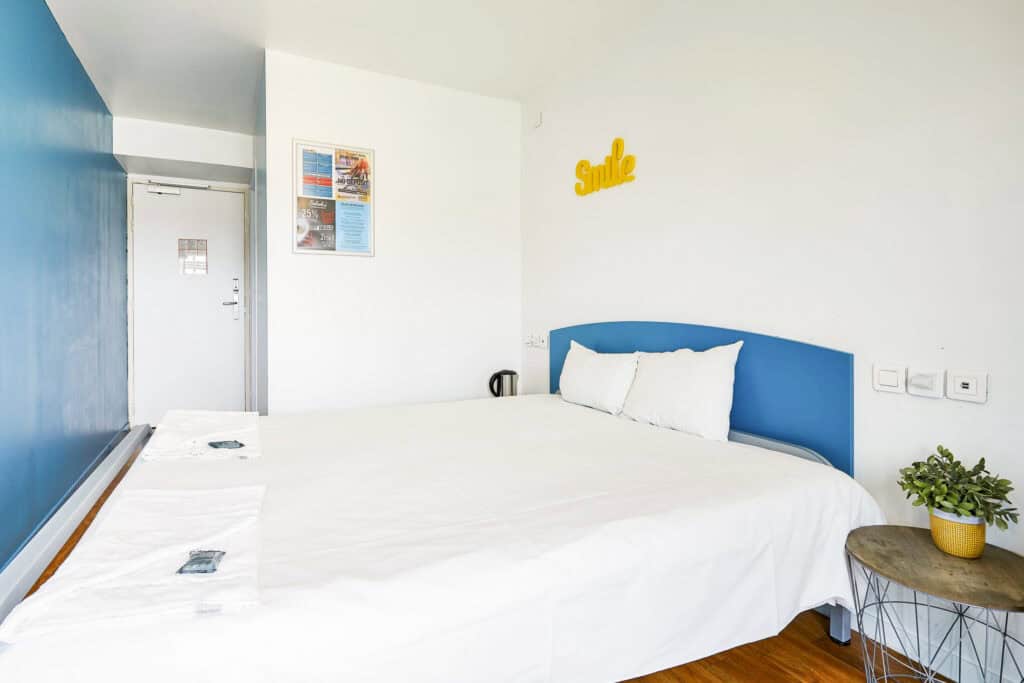 Bright hostel room with a large bed, colourful decor, and a relaxing atmosphere at St Christopher’s.
