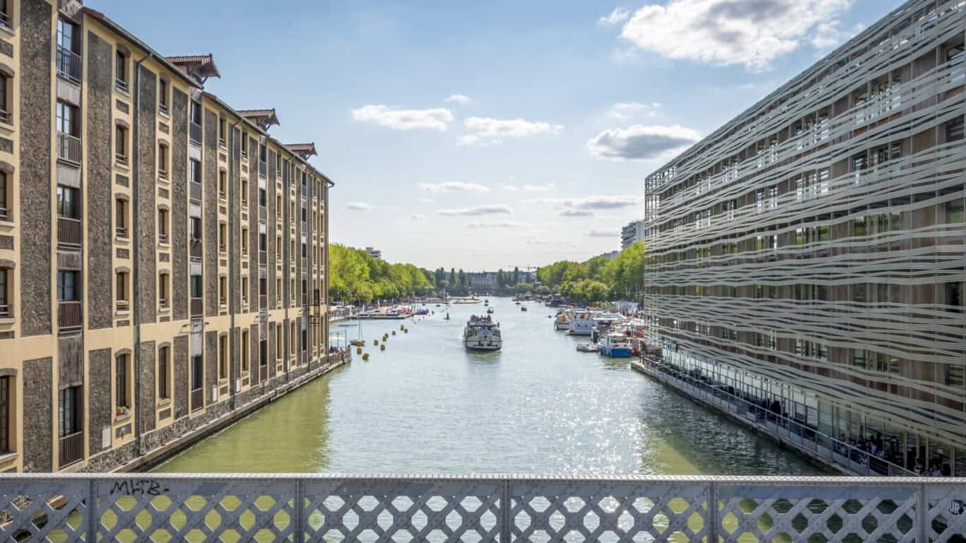 Canal view from St Christopher’s Paris hostel, showcasing modern architecture and boats on the water.