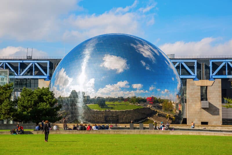 View of the reflective sphere at St Christopher's Paris - Canal with cityscape and sky.