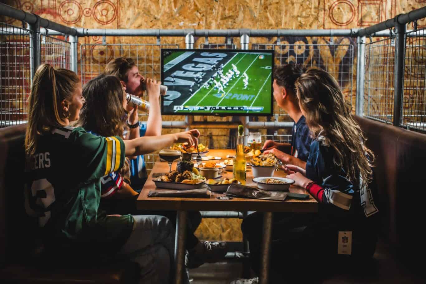 Football fans watching a match on a large screen at Shepherd's Bush Hostel.