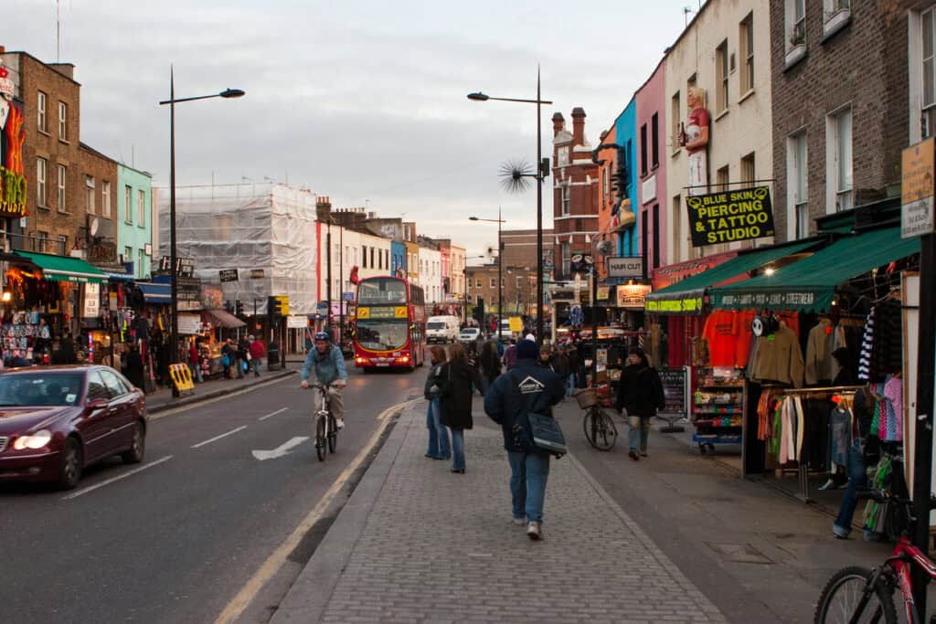 Shepherd's Bush street with shops, pedestrians, and cyclists in a lively urban setting.