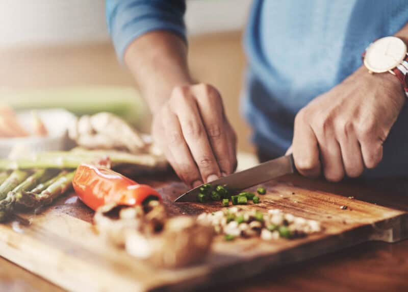 Vegetables being chopped on a wooden cutting board at Mitte Hostel, Berlin.