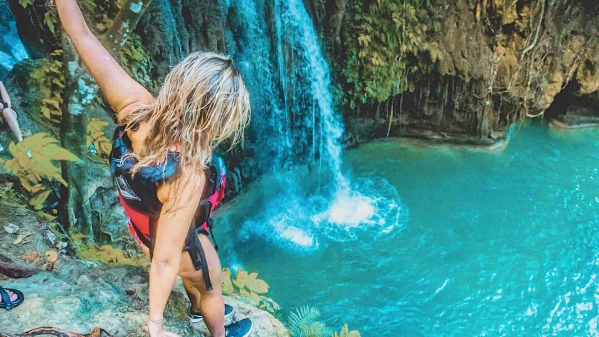 Woman enjoying a waterfall and turquoise pool at Mitte Hostel, Berlin.