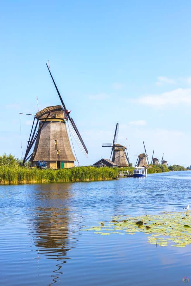 Traditional windmills on the Spree River in Berlin, Germany, with blue sky and water reflections.