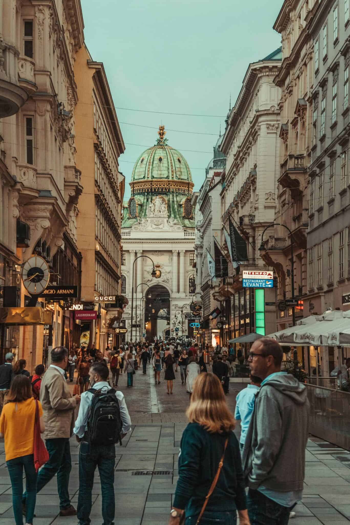 Bustling street scene in Vienna with St Christopher's Church in the background.
