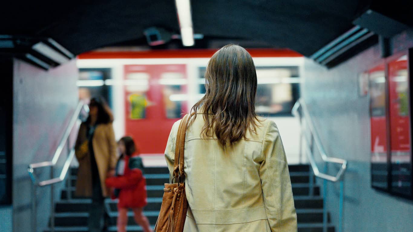 Mid Adult Woman Waits for Train in Barcelona Subterranean Station