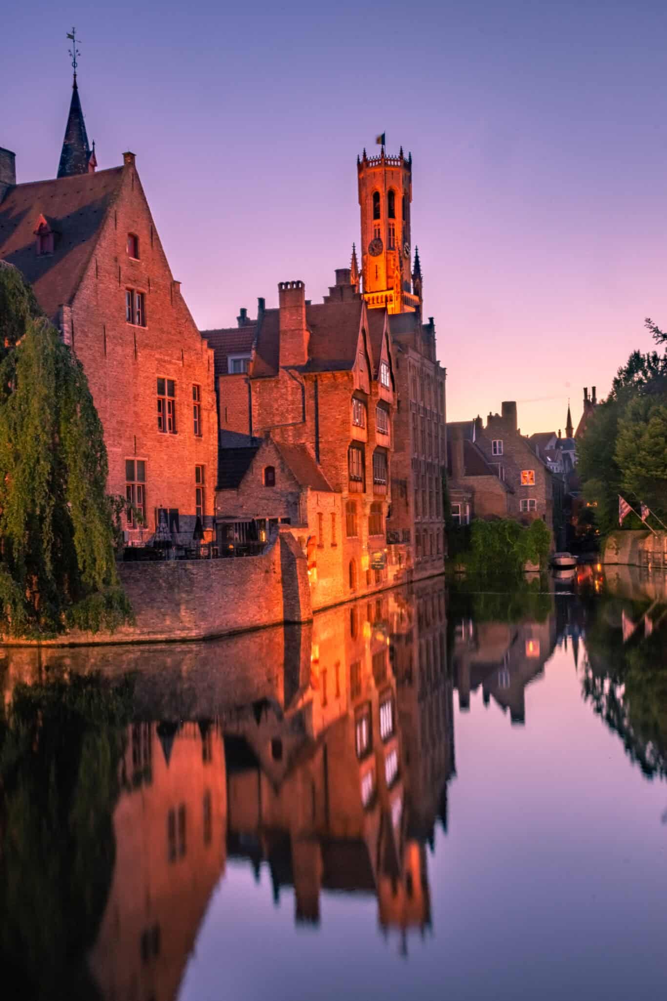 Bruges Belfry tower reflected in a canal at dusk – great-value youth hostel accommodation in the heart of Bruges