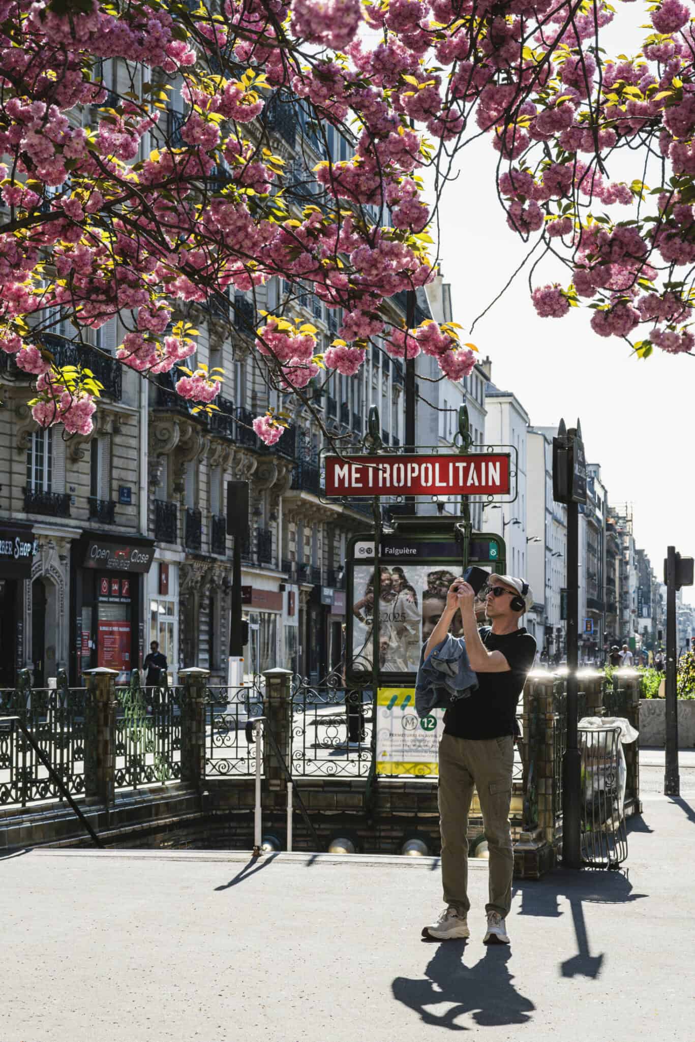 Traveller photographing a classic Paris Métropolitain sign in spring – great-value youth hostels in Paris with the city at your feet