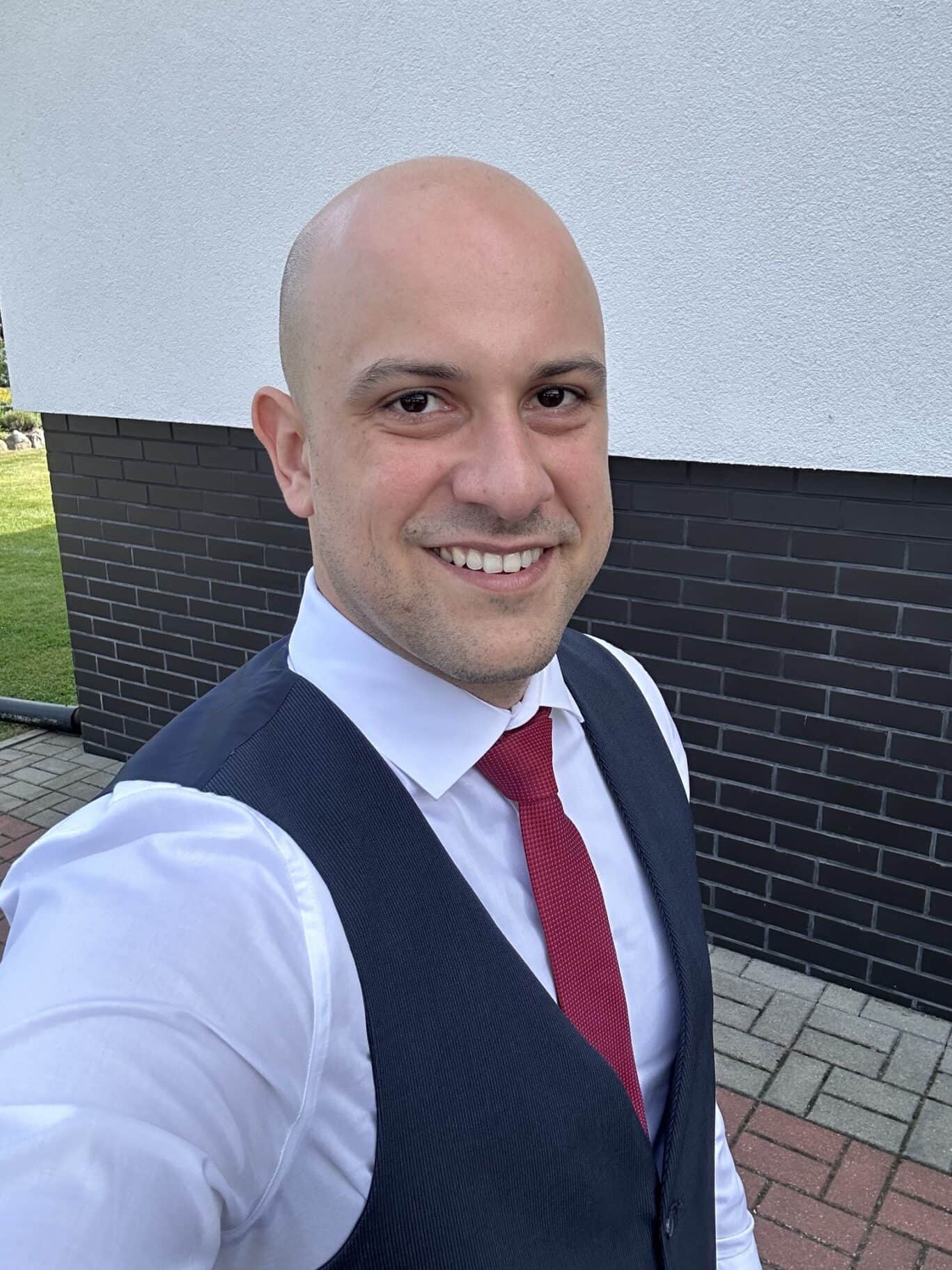 Smiling man in formal attire outside, representing St Christopher's.